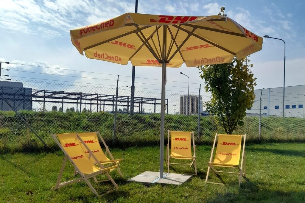 Dřevěná lehátka, reklamní slunečníky s potiskem DHL