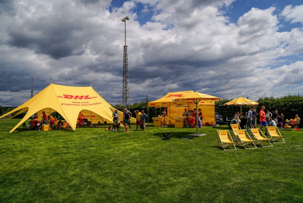 Párty stan jehlan, nůžkový párty stan 3x4,5, dřevěná lehátka, reklamní slunečníky s potiskem DHL